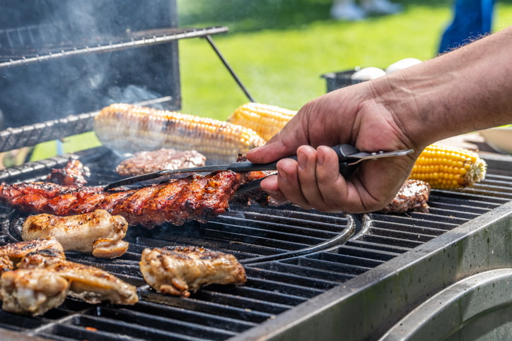 person barbequing food on grill