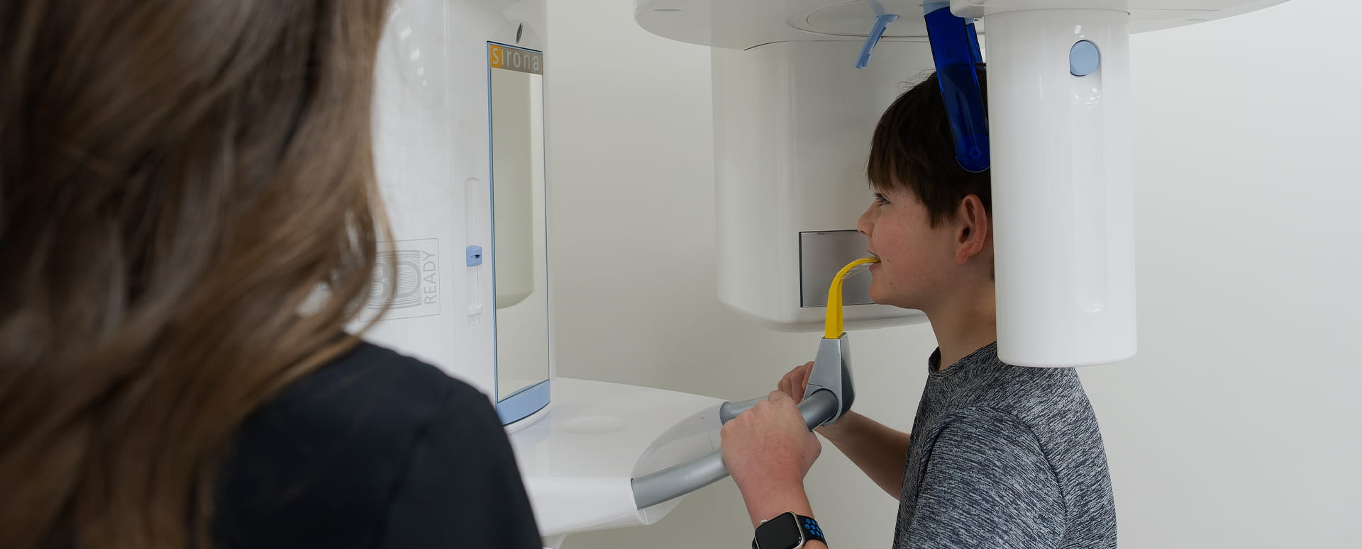 young male patient getting an x-ray at orthodontic office